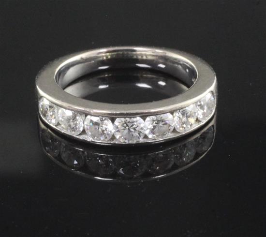 A modern 18ct white gold and channel set seven stone diamond half hoop ring, size M.